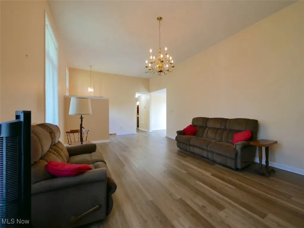 Living area featuring wood finished floors and a chandelier