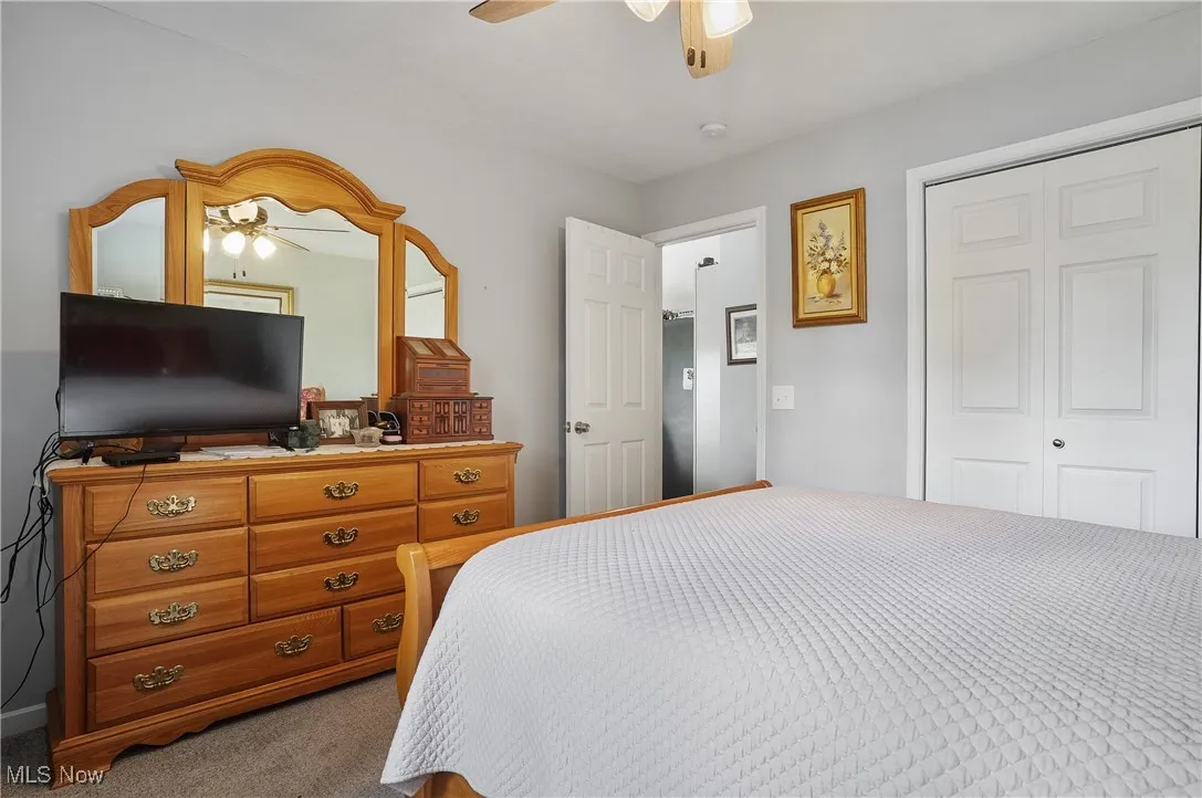 Bedroom featuring ceiling fan, a closet, and carpet floors