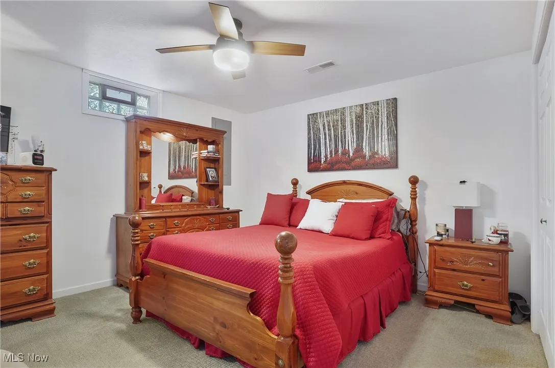 Carpeted bedroom featuring a ceiling fan and baseboards
