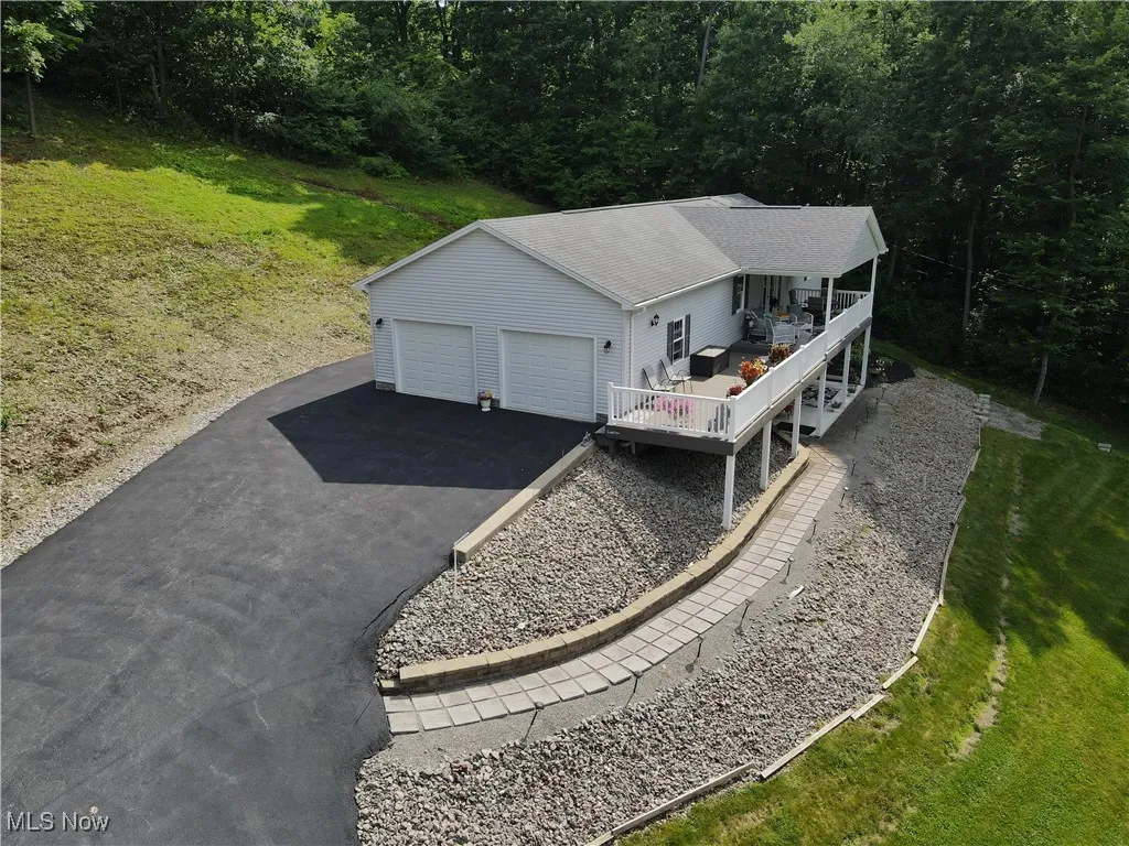 Aerial view of property and surrounding area featuring a forest