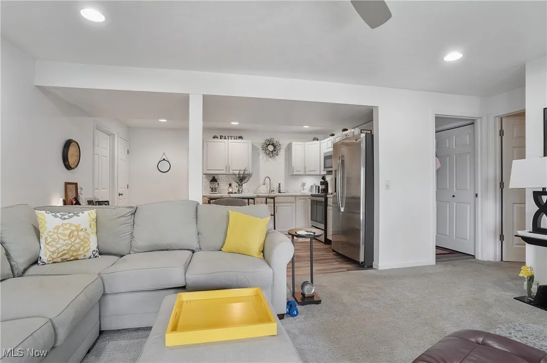 Living area with recessed lighting, light carpet, and ceiling fan