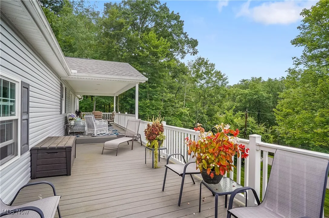 Deck with outdoor dining space and a forest view