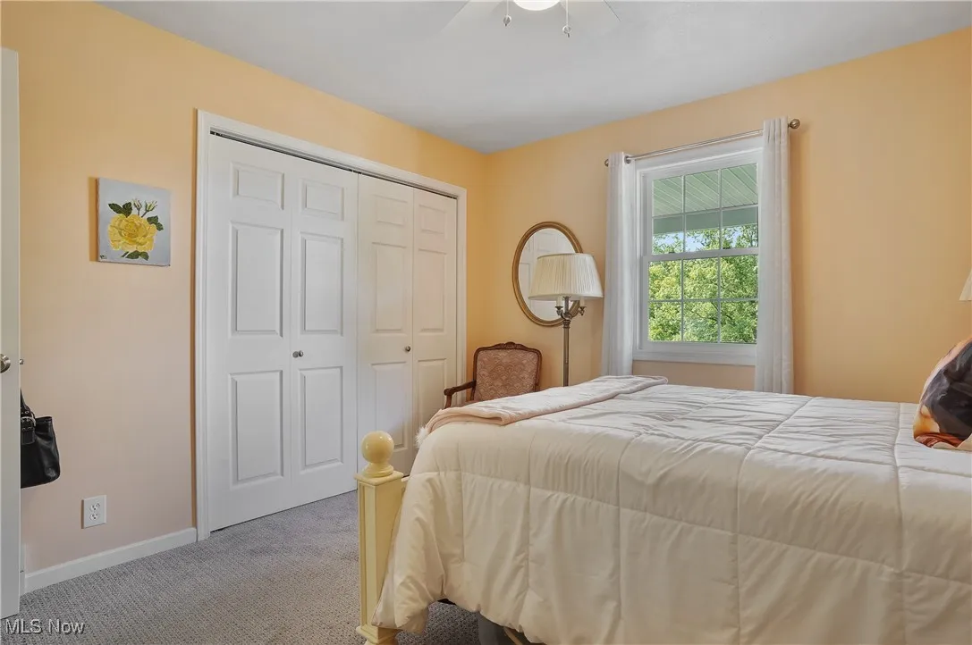 Carpeted bedroom with a closet and ceiling fan