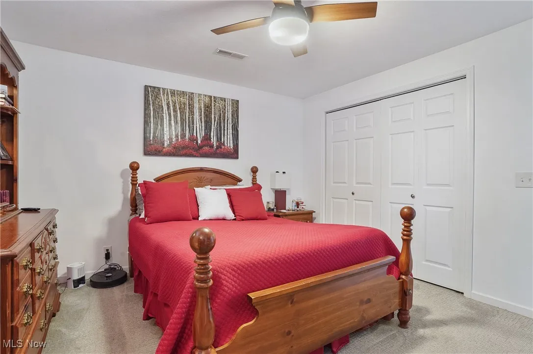 Carpeted bedroom featuring a closet and ceiling fan