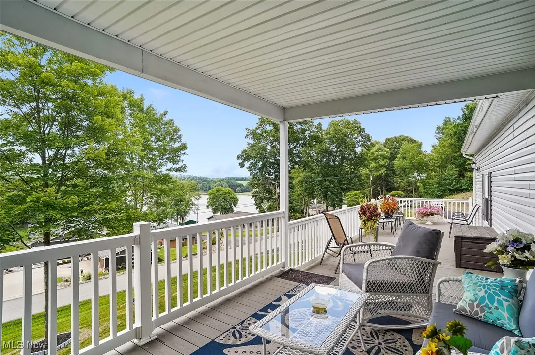 Wooden terrace featuring outdoor dining space and view of scattered trees