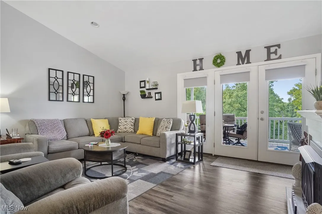 Living area with plenty of natural light, lofted ceiling, and wood finished floors