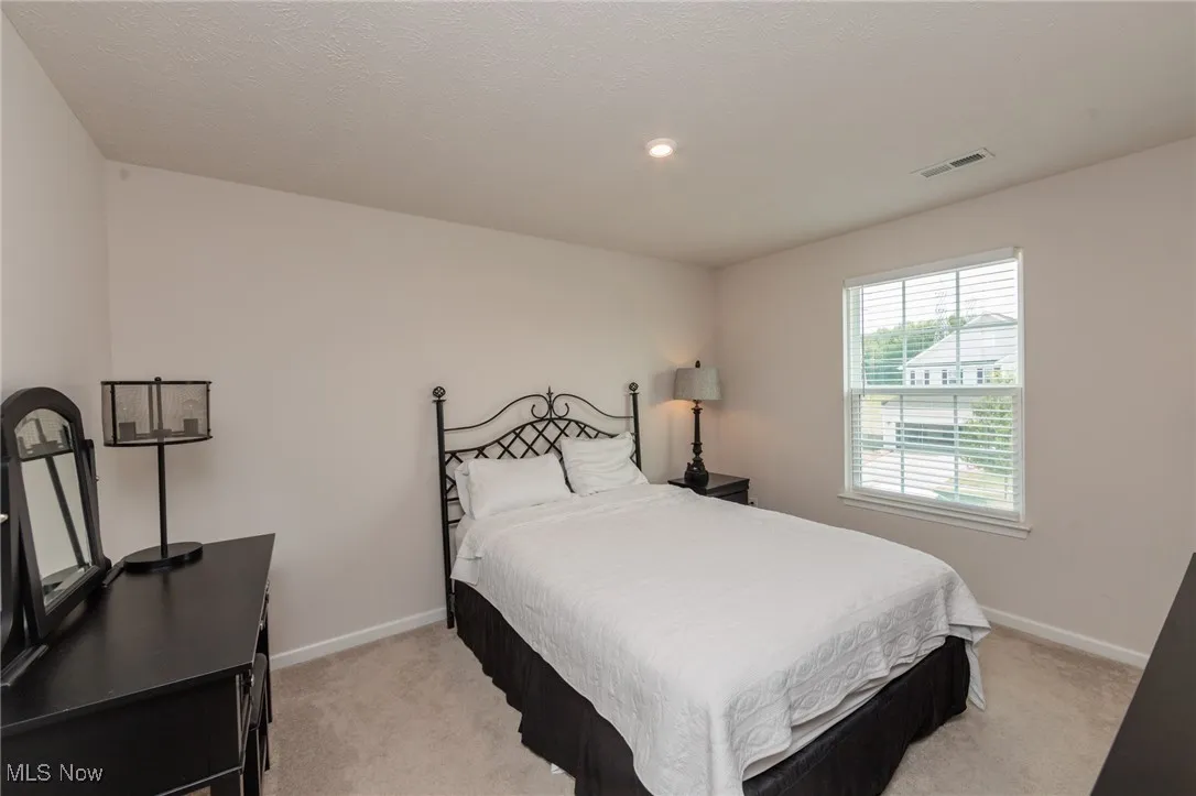 Bedroom featuring baseboards and light colored carpet