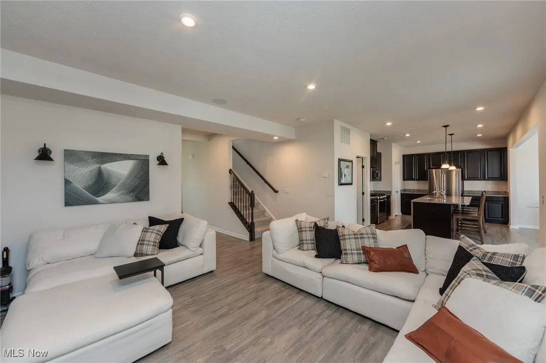 Living room featuring stairway, light wood-style floors, and recessed lighting