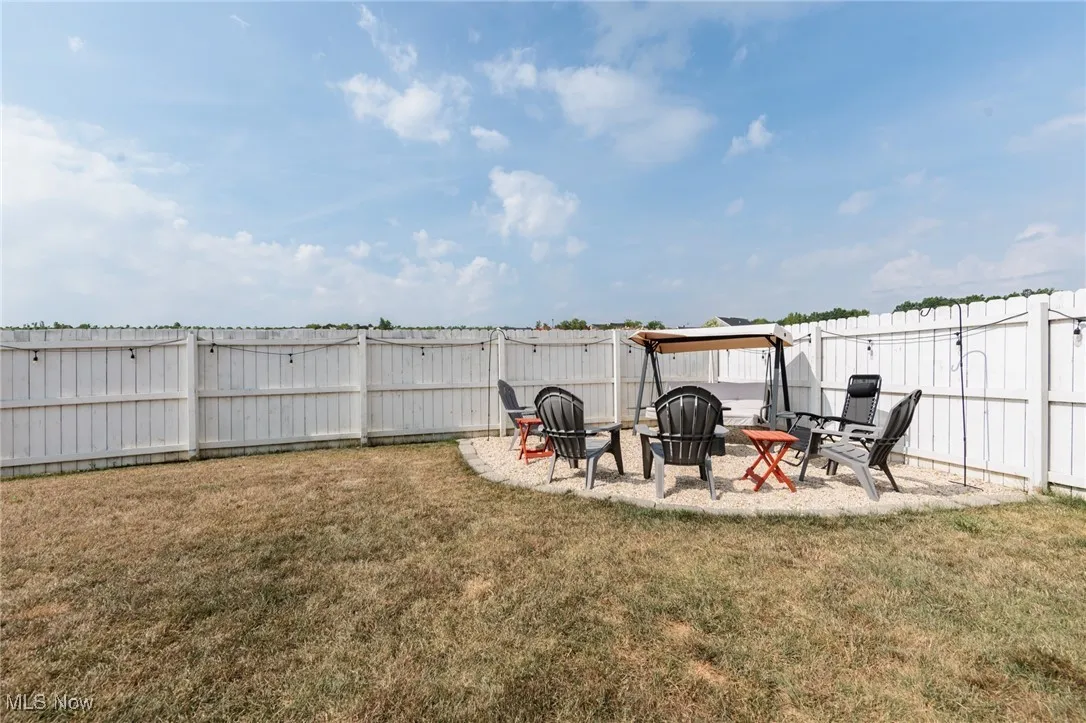 Fenced backyard featuring a fire pit