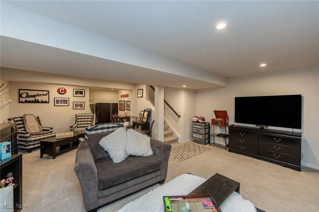 Living room with carpet flooring, stairway, and recessed lighting