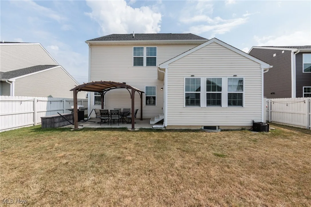 Rear view of house with a patio area and a fenced backyard