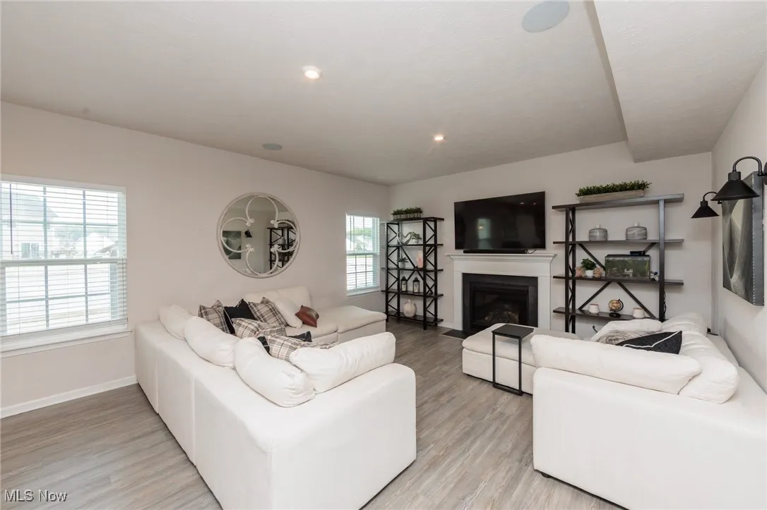 Living area featuring light wood-style flooring and a fireplace with flush hearth