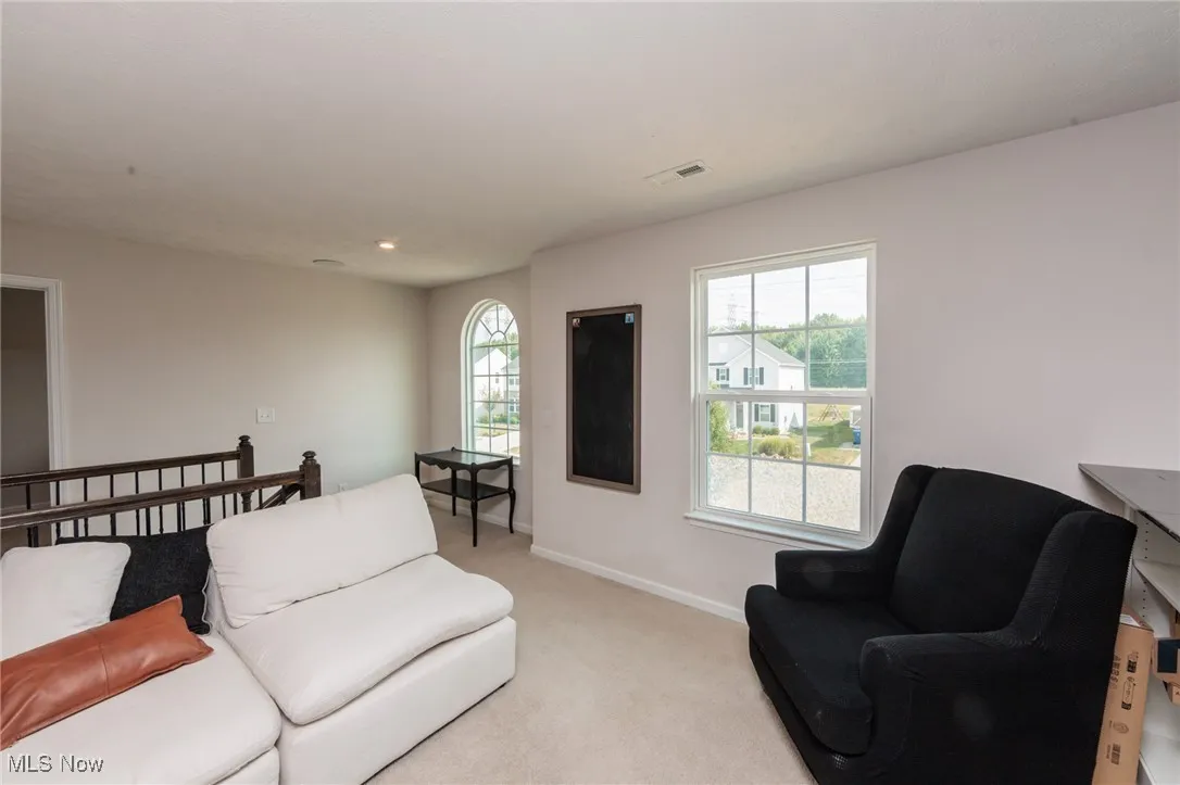 Living area with light carpet and plenty of natural light
