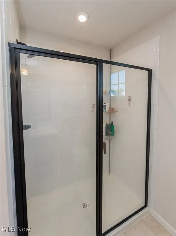 Bathroom featuring a stall shower, tile patterned flooring, and recessed lighting