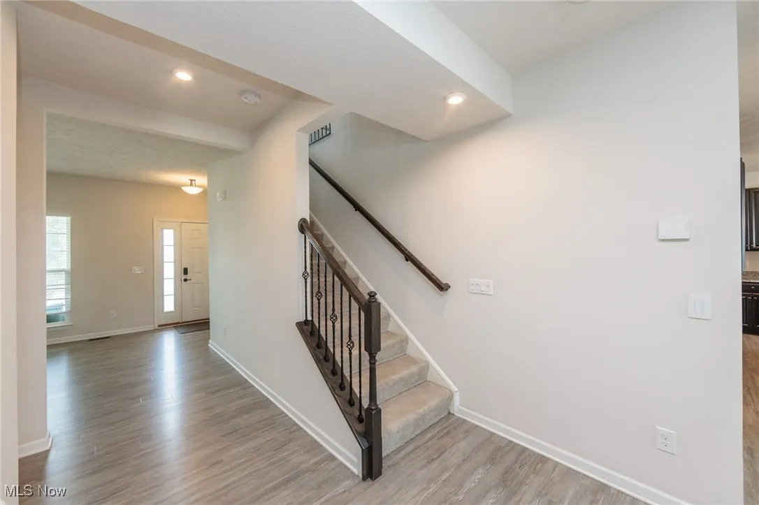 Staircase featuring wood finished floors and recessed lighting