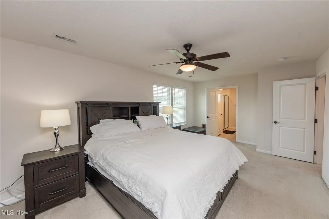 Bedroom featuring light colored carpet and ceiling fan