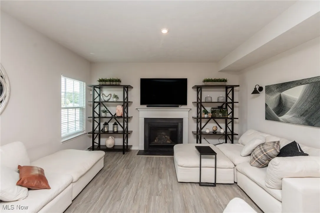 Living area with light wood-type flooring and a fireplace with flush hearth