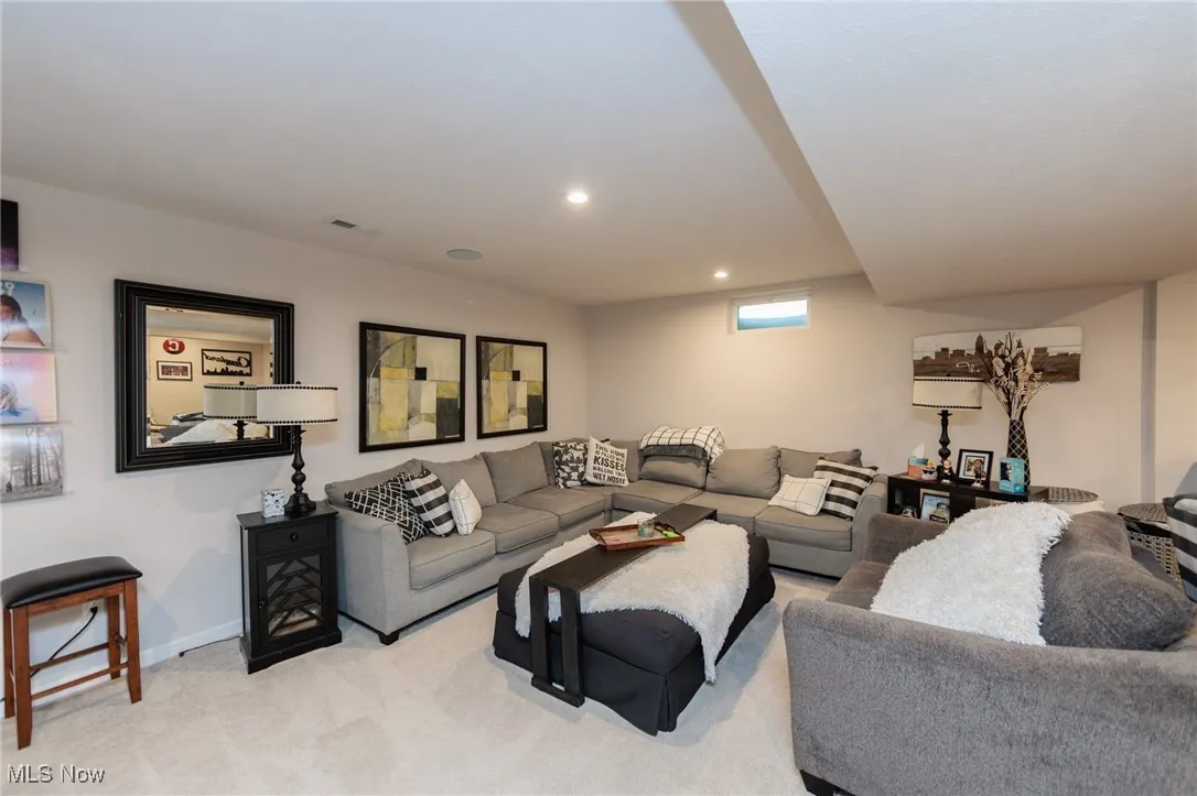 Living area featuring light colored carpet and recessed lighting
