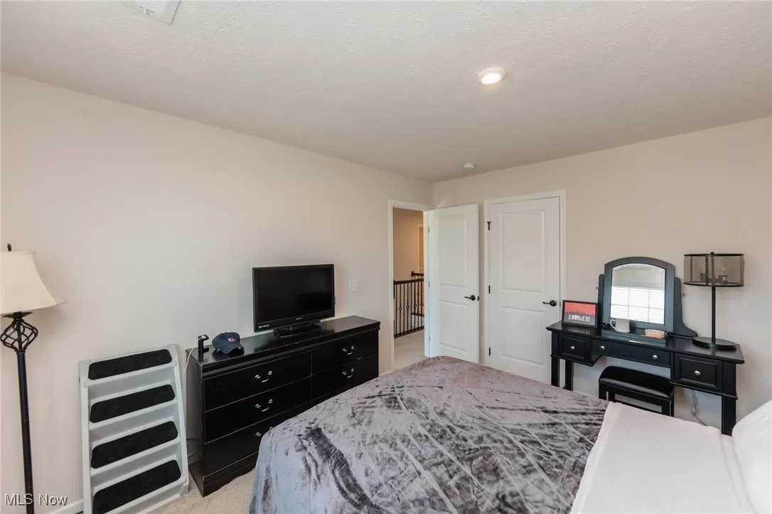Bedroom with light carpet and recessed lighting