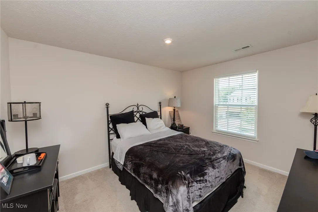 Bedroom with light carpet and recessed lighting