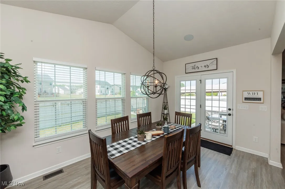 Dining room featuring a chandelier, light wood finished floors, and vaulted ceiling
