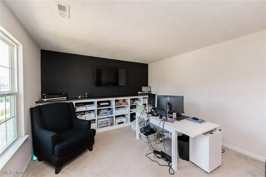 Home office with light carpet and baseboards