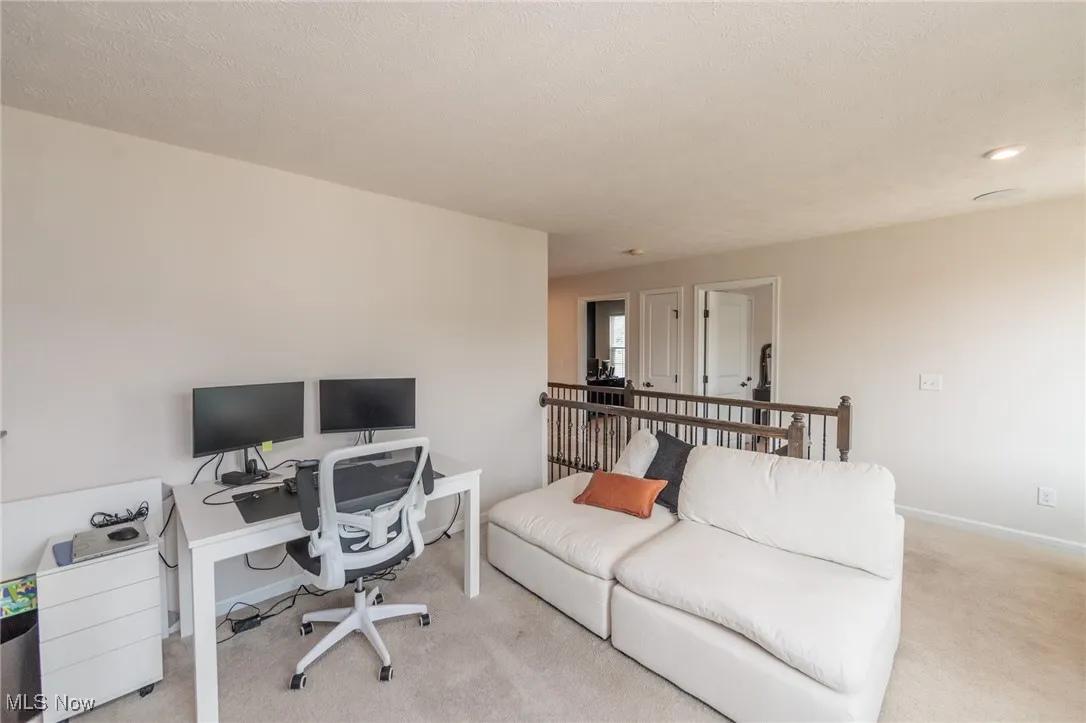 Office space featuring light colored carpet, a textured ceiling, and recessed lighting