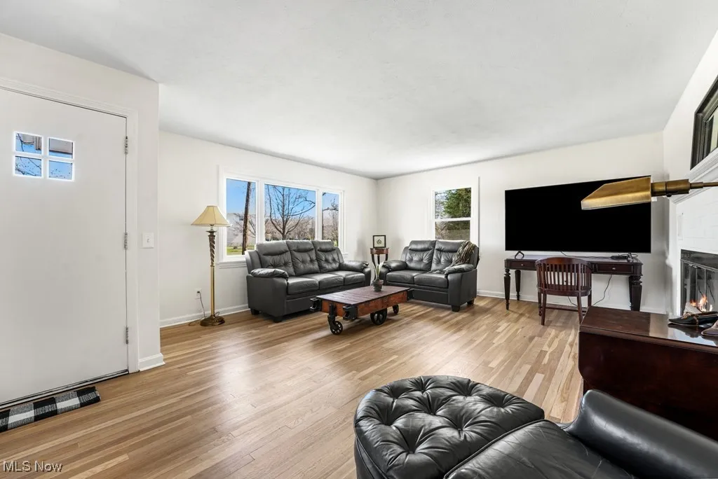 Spacious living room features a cozy wood-burning fireplace