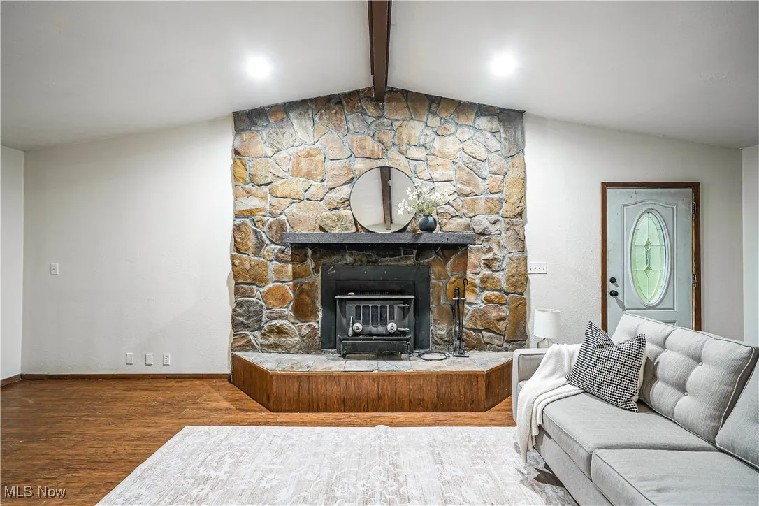 Living area with wood finished floors and a stone fireplace