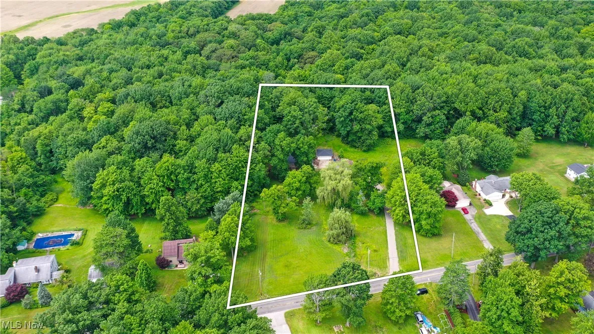 View of property location with a heavily wooded area and property boundaries highlighted