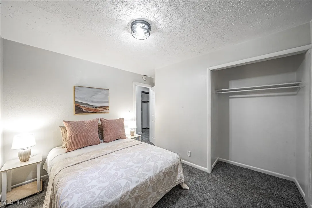 Bedroom with carpet, a closet, and a textured ceiling