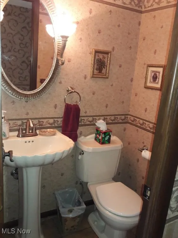 Half bath with wallpapered walls