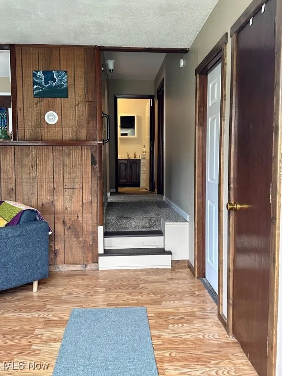 Hallway featuring wood finished floors and a textured ceiling