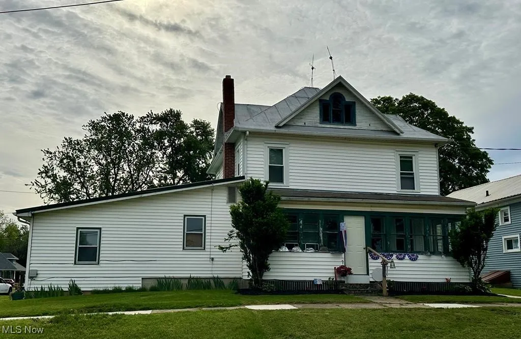 View of front of home with a chimney, a front lawn, and entry steps
