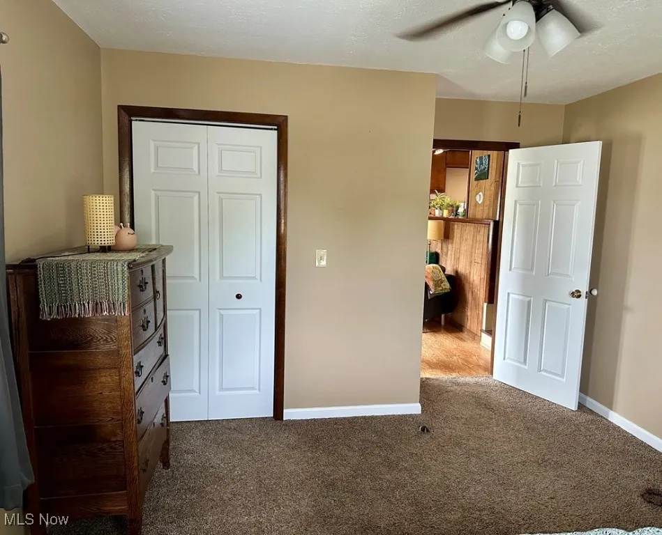 Bedroom with carpet, a closet, and a ceiling fan