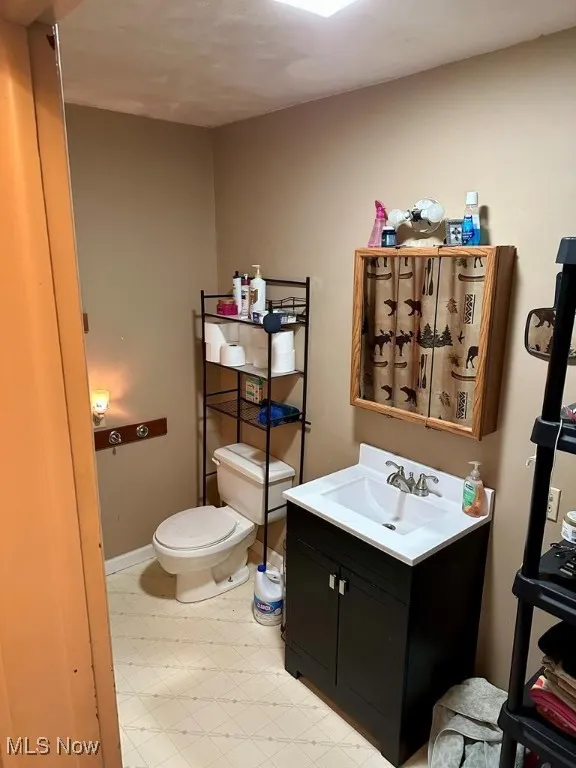 Half bath with tile patterned floors and vanity