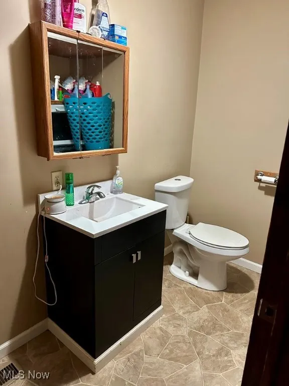 Half bath with vanity and tile patterned flooring