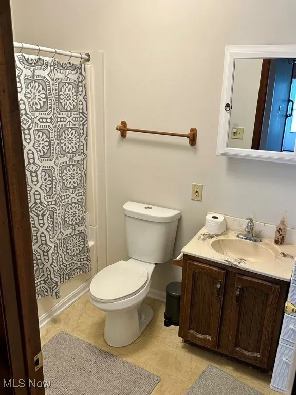 Bathroom featuring vanity and shower / bath combination with curtain