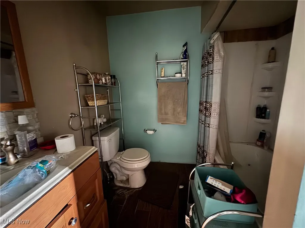 Full bathroom featuring vanity, tasteful backsplash, and shower / bathtub combination with curtain