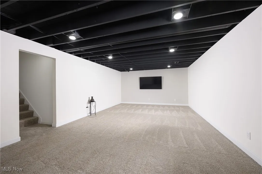 Finished basement with carpet floors and stairs
