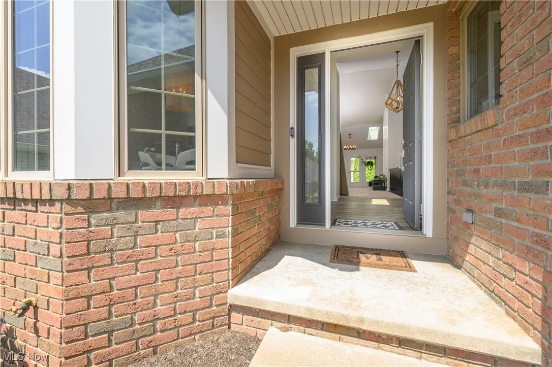 Doorway to property featuring brick siding