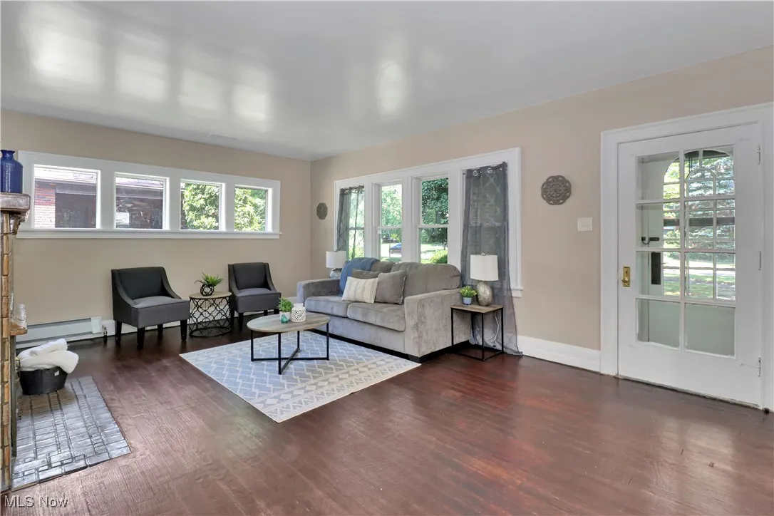 Living room featuring dark wood finished floors and a baseboard radiator