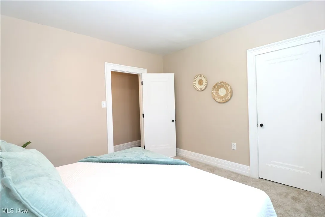 Bedroom with light carpet and baseboards