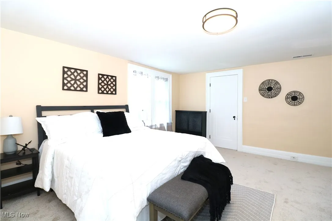 Bedroom with baseboards and light carpet