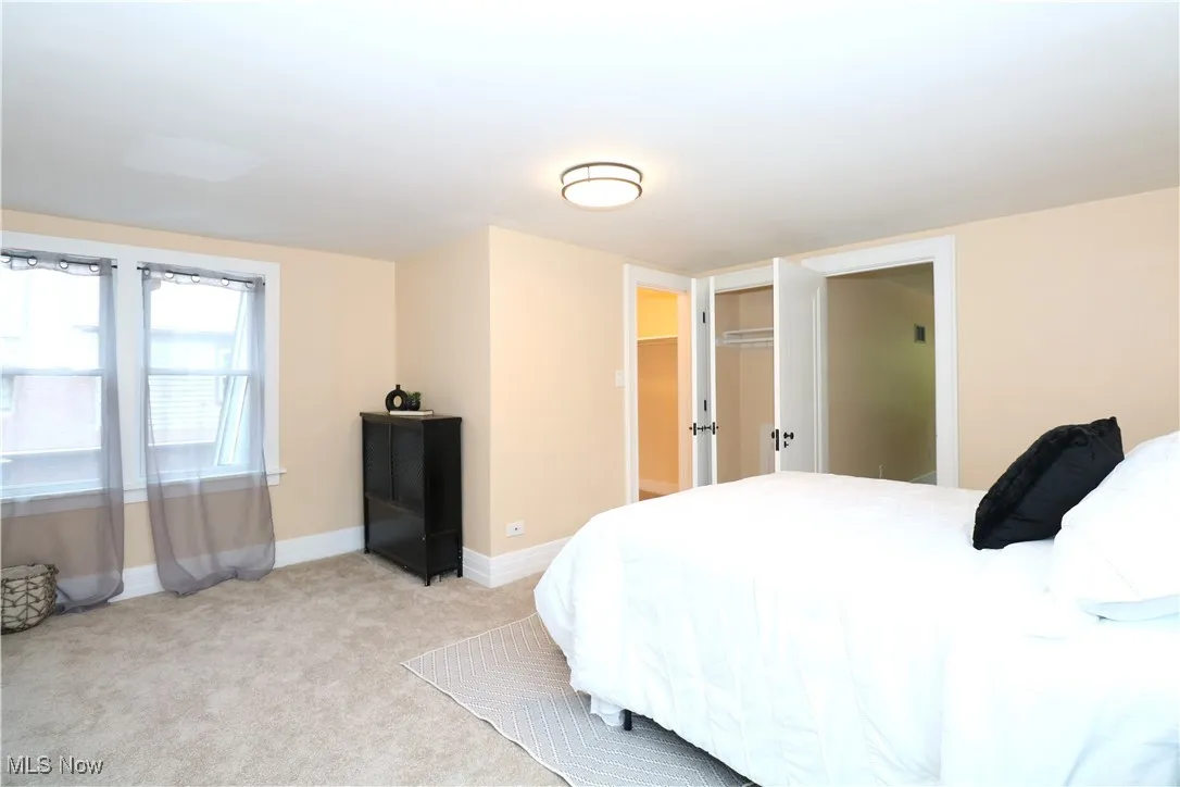 Bedroom with baseboards and light carpet