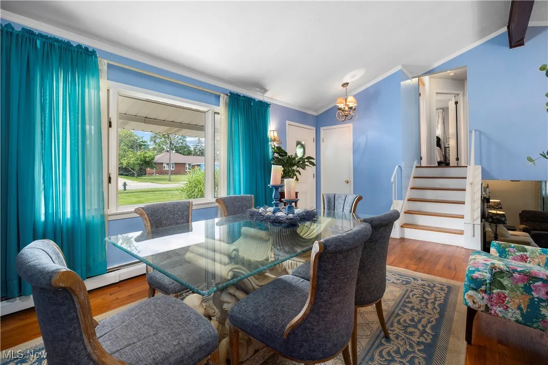 Dining space with vaulted ceiling, crown molding, and Anderson picture window