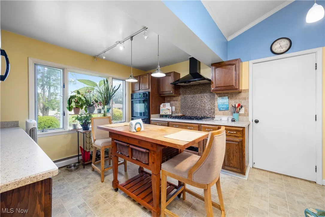 Kitchen with tasteful backsplash, and ornamental molding