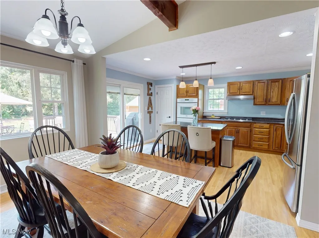 Dining room with light wood-type flooring, plenty of natural light, a chandelier, recessed lighting, and ornamental molding