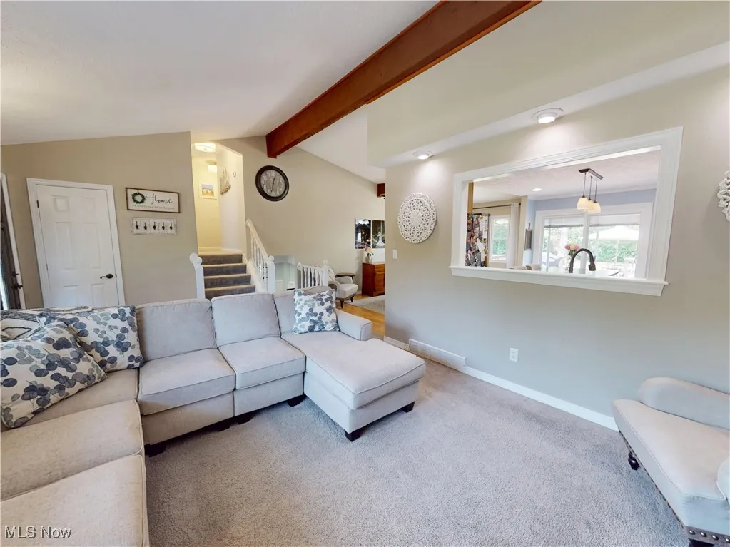Living area with stairway, radiator heating unit, and carpet floors