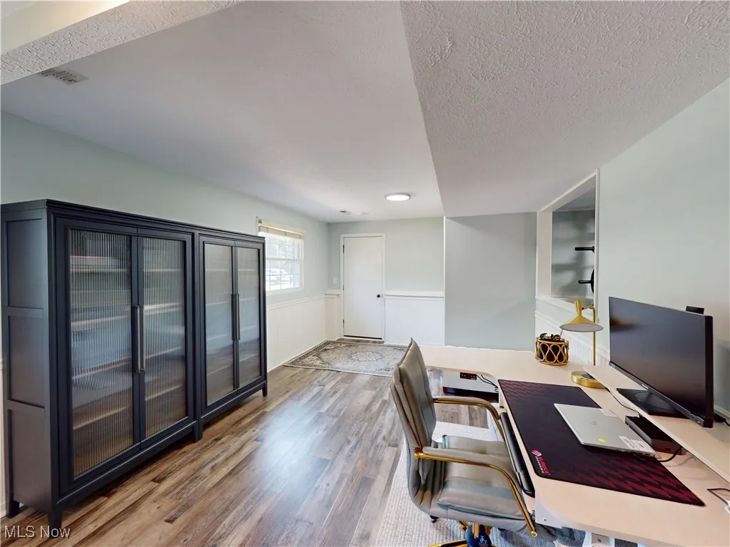 Office with wood finished floors and a textured ceiling